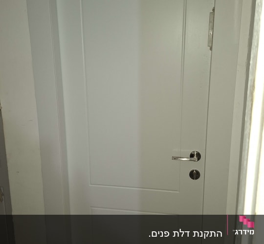 דלת לבנה עם ידית כסופה